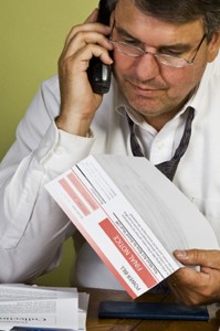 Photo Of A Man On The Telephone Holding A Bill